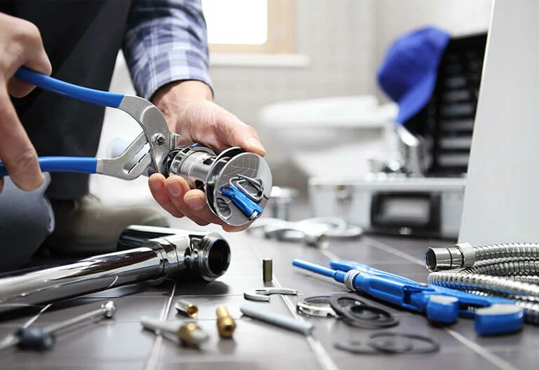 Technician repairing a plumbing fixture with professional tools in Palm Harbor