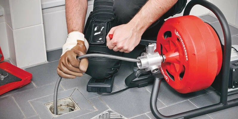 Plumber using a drain-cleaning machine in Palm Harbor