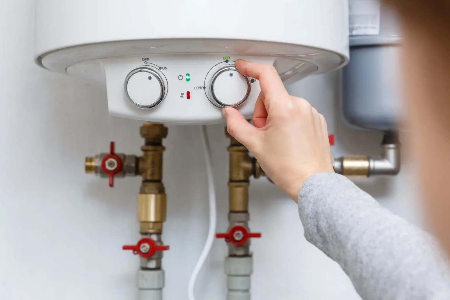 Homeowner adjusting the temperature controls on a water heater in Palm Harbor